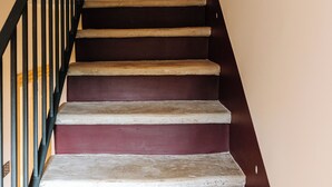 A staircase with wooden steps and a black railing. - Palazzina Gentile (Bari)