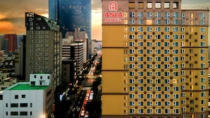 Eine Stadtansicht mit einem markanten Gebäude, auf dem „Asia Hotel“ steht.