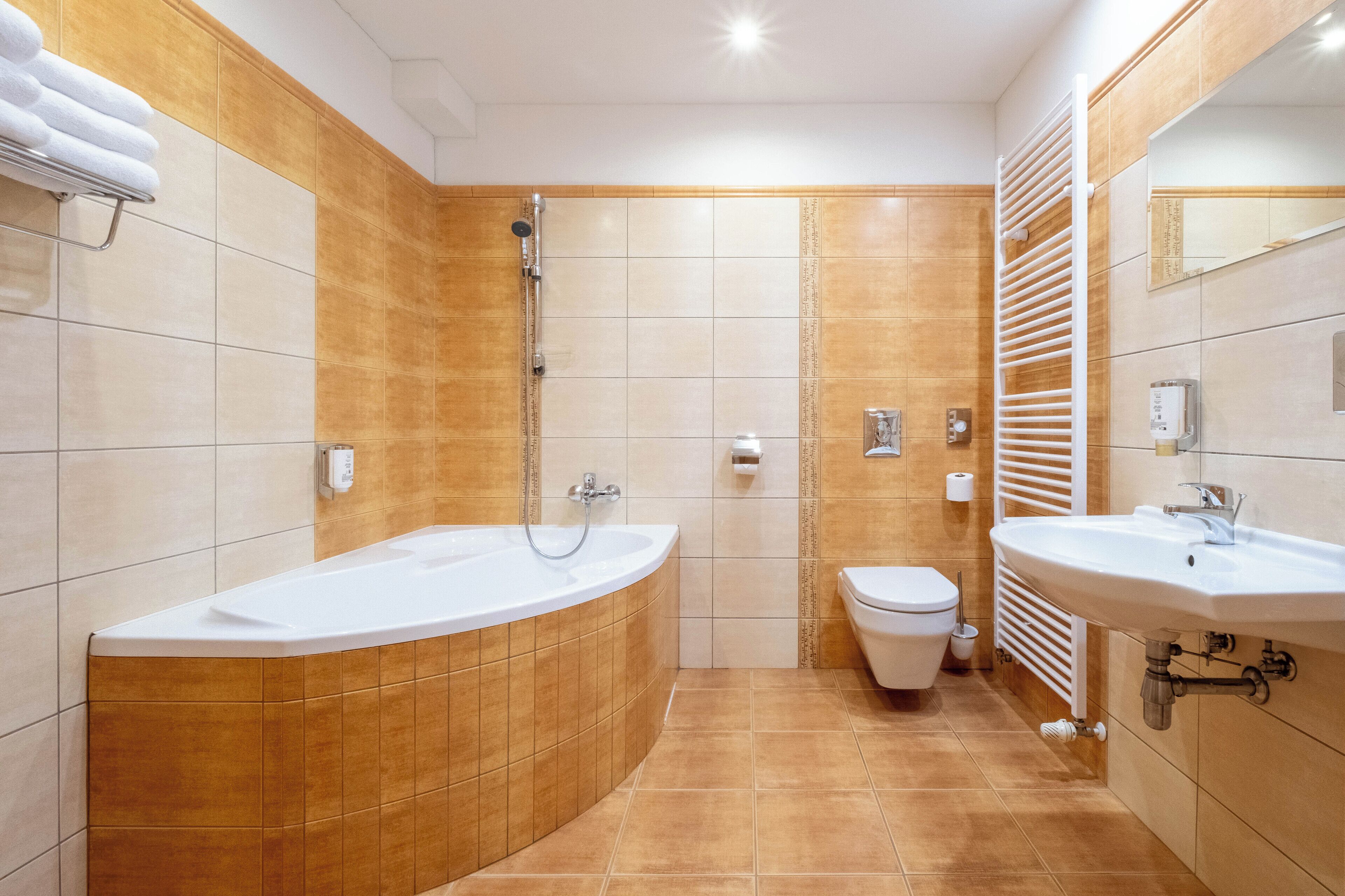 Un baño moderno con una bañera independiente, inodoro y lavabo.