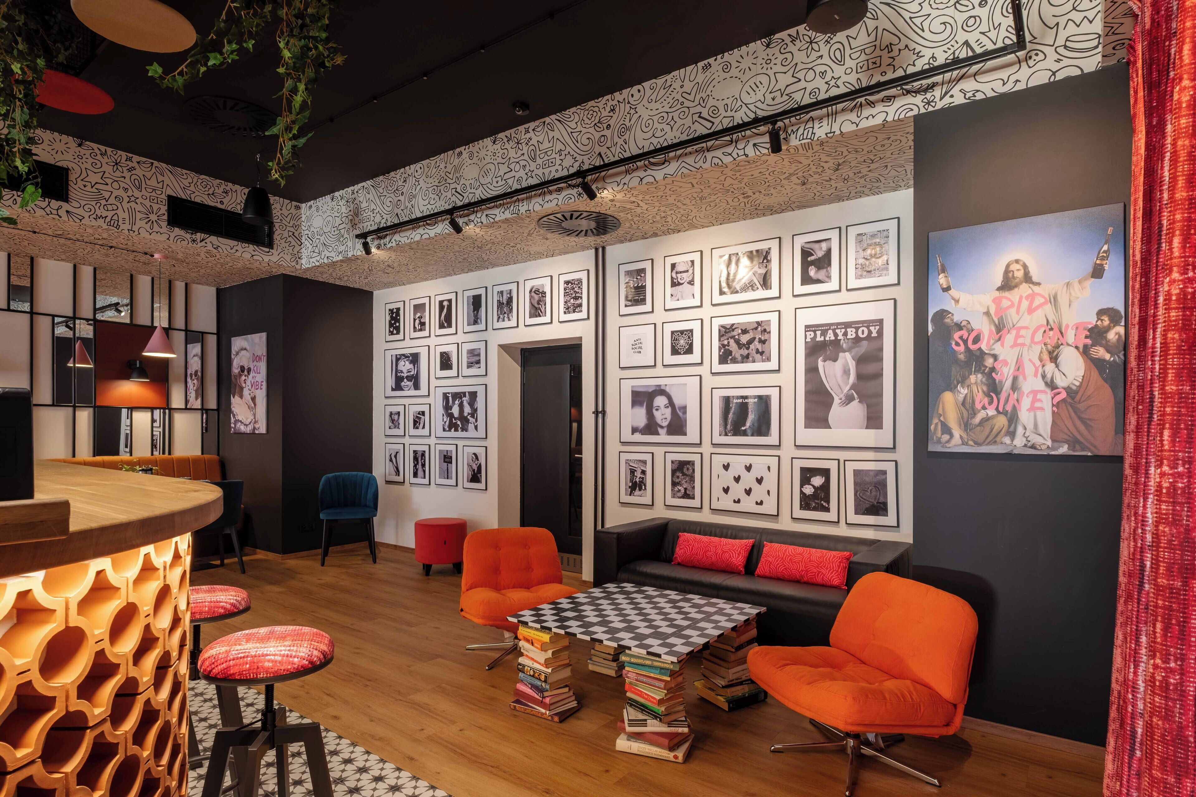 Un área de descanso moderna con bar, asientos y una pared decorada con cuadros enmarcados.