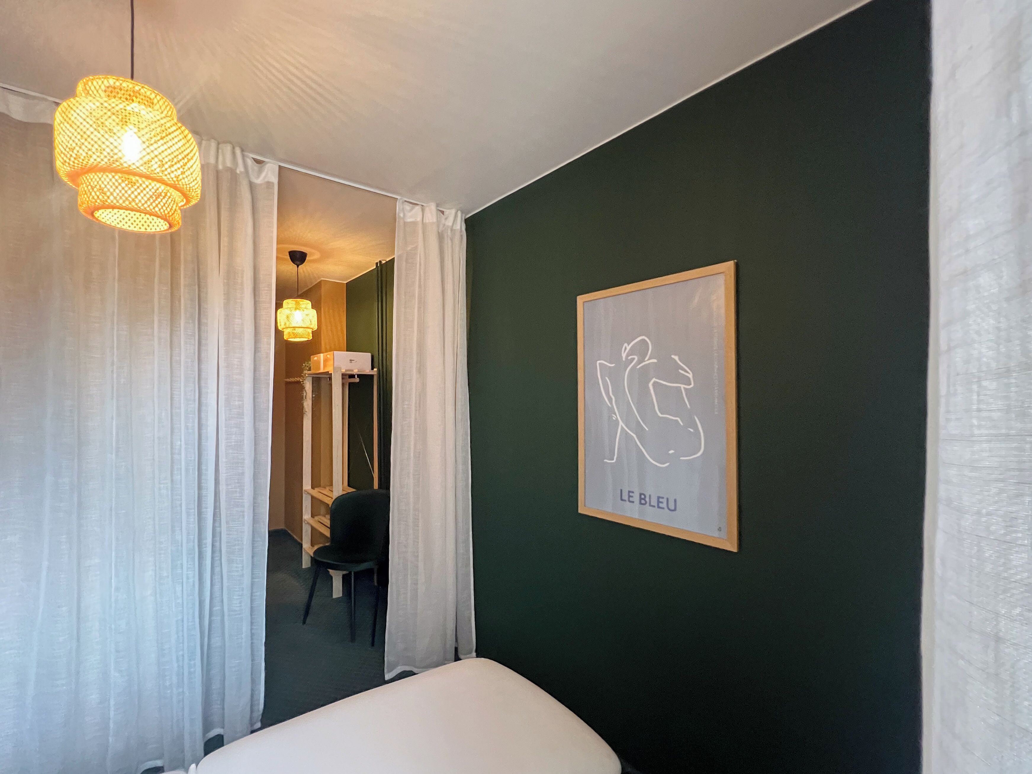 Ein Hotelzimmer mit einem Bett, einem gerahmten Kunstwerk an der Wand und einer Tür zu einem Badezimmer.