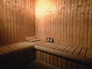 A sauna with wooden benches and a clock. - Taj Celine Hotel (Jeddah)
