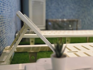 A model pool with a white lounge chair and a small potted plant. - Taj Celine Hotel (Jeddah)