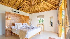 Une chambre avec une tête de lit en bois, un lit recouvert de draps blancs, une table de chevet, une fenêtre donnant sur un beau paysage et un plafond en bambou.