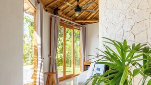 Une pièce dotée d’une grande porte-fenêtre coulissante, d’un ventilateur de plafond et d’une plante en pot.
