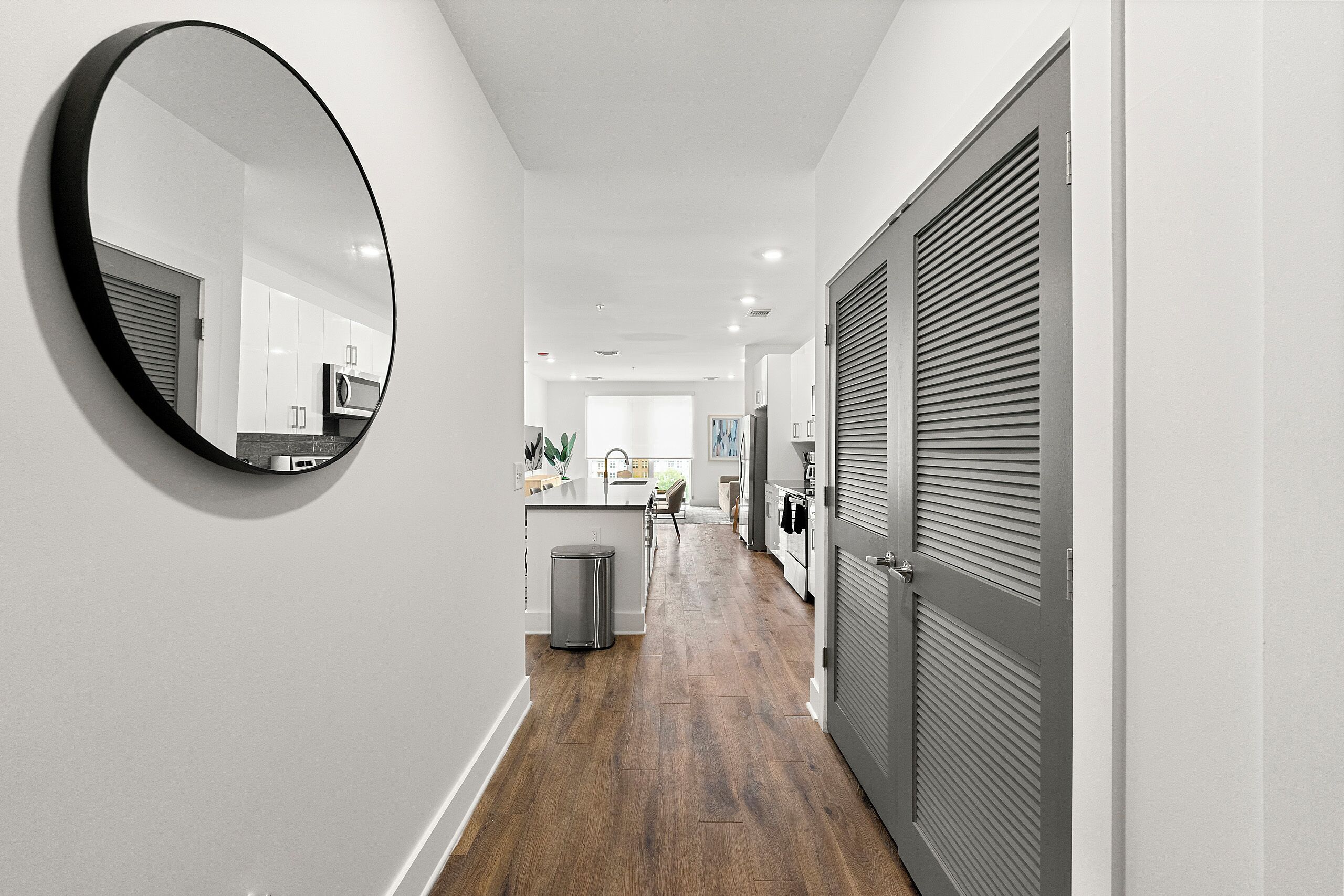 A modern kitchen with white cabinets, a stainless steel sink, and a microwave.