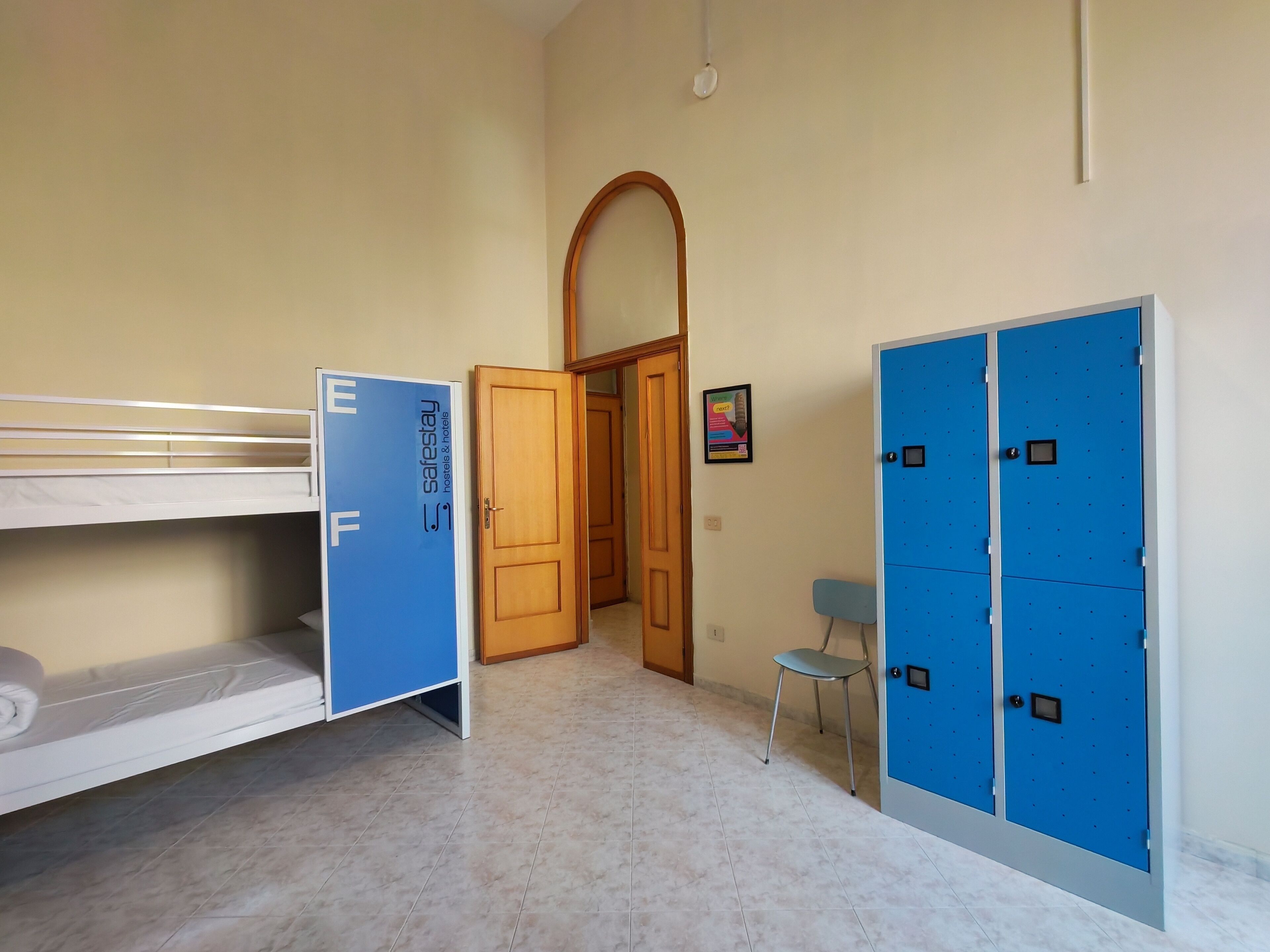 Una habitación de hotel con literas, un armario, un escritorio y una silla.