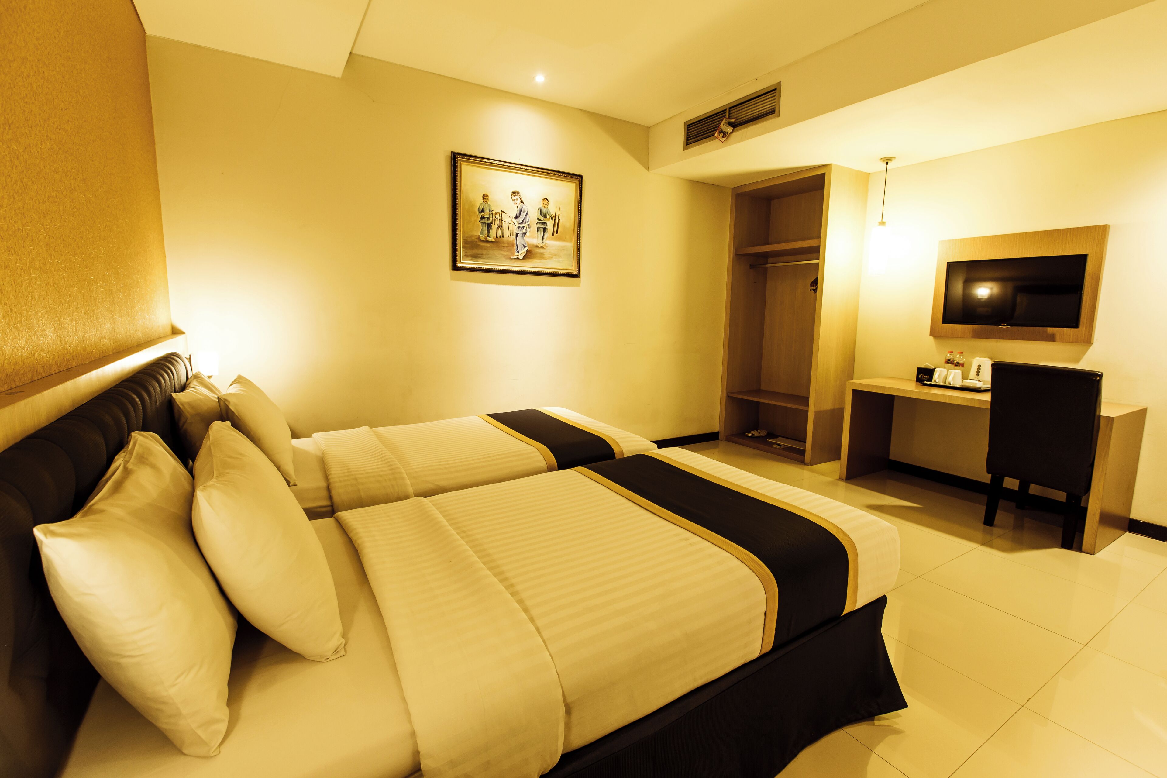 A hotel room with a bed, a desk, a TV, and a wardrobe.