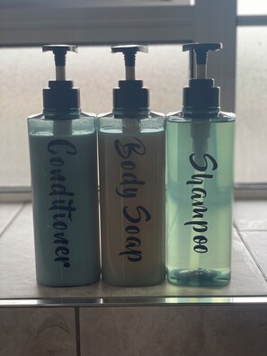 Three bottles of liquid on a tiled surface.