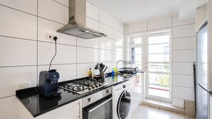 Een moderne keuken met een gasfornuis, oven en een ingebouwde wasmachine.
