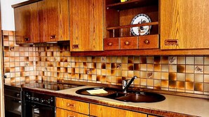 A kitchen with wooden cabinets, a tiled backsplash, and a dishwasher. - Apartment 'Natascha' with Mountain View, Shared Terrace and Wi-Fi (Fellen)