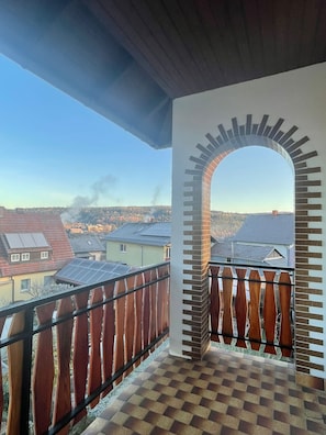 Ein Balkon mit Blick auf Häuser und einen klaren Himmel.