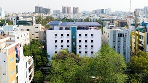 A multi-story building with a central courtyard surrounded by trees. - Hotel Marigold Atnest Gachibowli (Hyderabad)