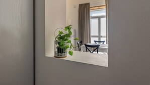 Ett modernt vardagsrum med en vit soffa, ett soffbord och en krukväxt.