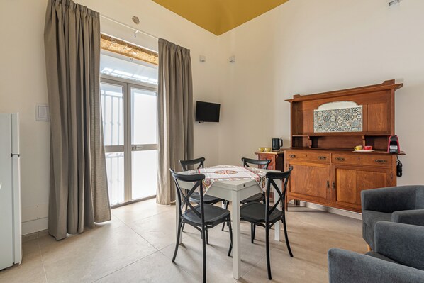Un comedor con una mesa, sillas y un mueble de madera con salpicadero de azulejos.
