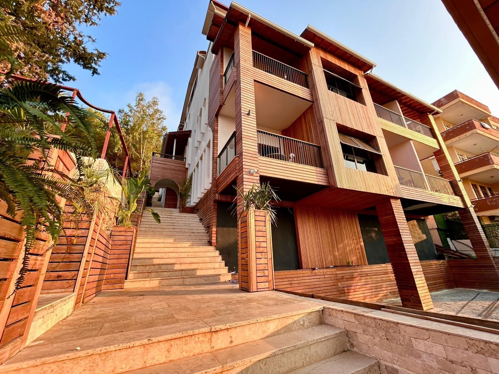 Un edificio residencial de varios pisos con una escalera que lleva a la entrada.