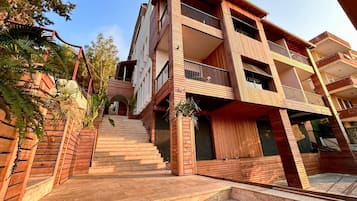 Un edificio residencial de varios pisos con una escalera que lleva a la entrada.