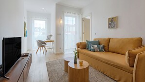 A living room with a sofa, a TV, and a coffee table.