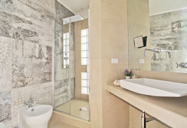 Regadera, secadora de cabello, bidet, toallas
