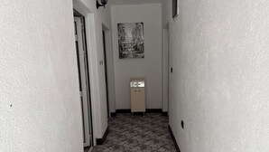 A narrow hallway with patterned tile flooring, white walls, and a small cabinet with a sink. - 🛏 Apartment 1 - Anna-Nikola, Central Igalo, 5-Min to Beach (Igalo)