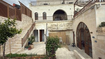A courtyard with stone walls, a staircase, and a small garden area.