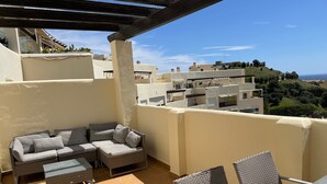 A balcony with a sofa, chairs, and a table. - Apartment 'Benalmadena Home' with Sea Views, Wi-Fi and Air Conditioning (Benalmádena)