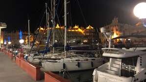 A marina at night with boats docked, a large illuminated building in the background, and a clear sky. - Apartment 'Benalmadena Home' with Sea Views, Wi-Fi and Air Conditioning (Benalmádena)