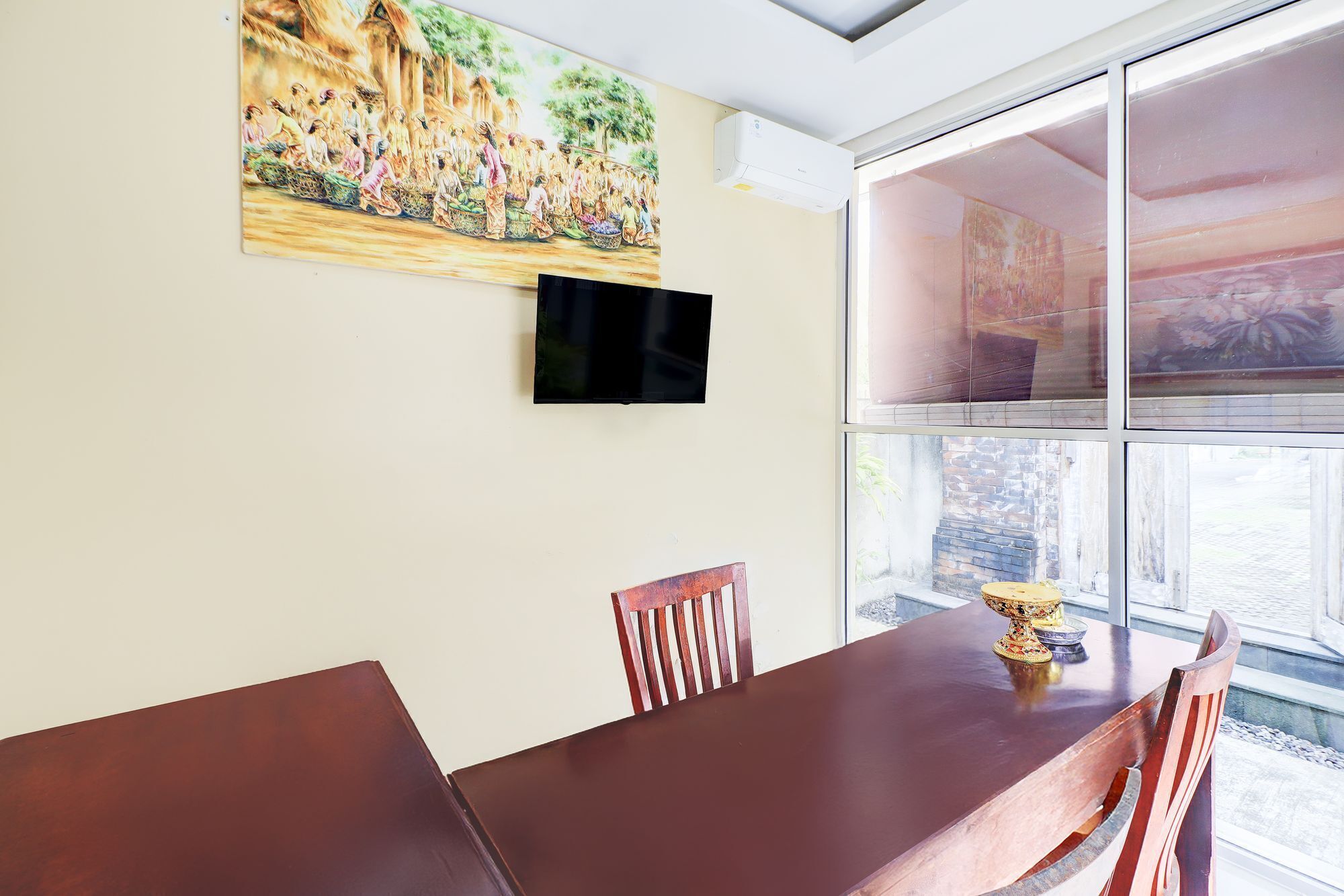 Een eetgedeelte met een grote tafel en stoelen, een flatscreen televisie aan de muur en een groot raam met uitzicht.