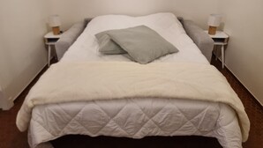 A single bed with a quilted white duvet, a grey pillow, and two bedside lamps on white nightstands. - Collioure - Bright studio for 2 people 5 min from the beach (Collioure)
