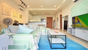 A modern living room with a sofa, a coffee table, and a TV. - Homie's The Glory Apartment (Ho Chi Minh City)
