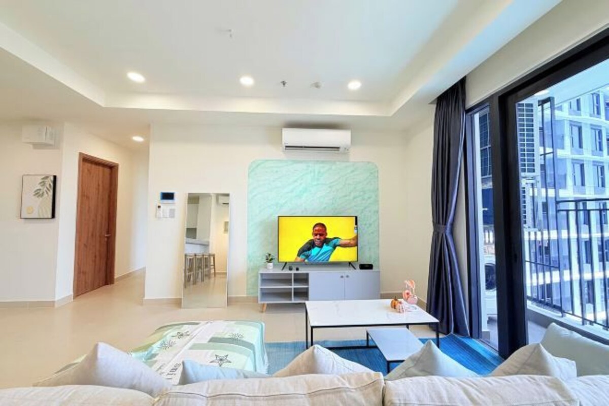 Habitación de hotel moderna con un gran ventanal, televisión de pantalla plana, zona de comedor y una cama con vistas.