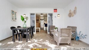 A dining area with a table and chairs, a kitchen in the background, and a decorative peacock on the floor. - Apartment 'Romance' with Shared Pool, Private Terrace and Wi-Fi (Puerto del Carmen)