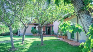 A well-maintained garden with a house featuring a front porch and a door. - Villa Belvedere on the Tuscan Hills (Toscana)