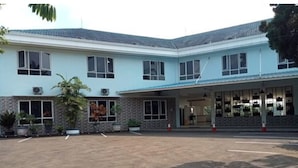A two-story building with a flat roof, large windows, and a covered entrance area.