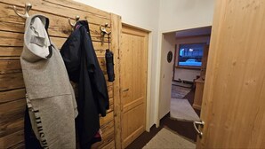 Un pasillo con puertas de madera y un perchero.