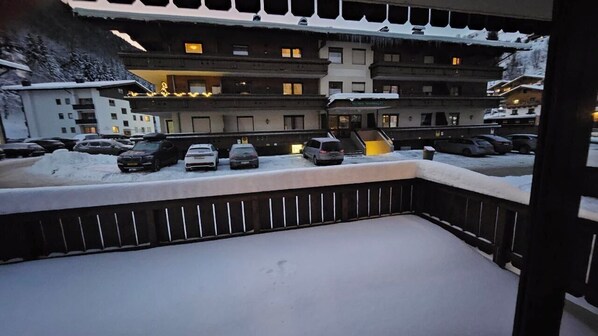 A snow-covered parking area with several cars parked.