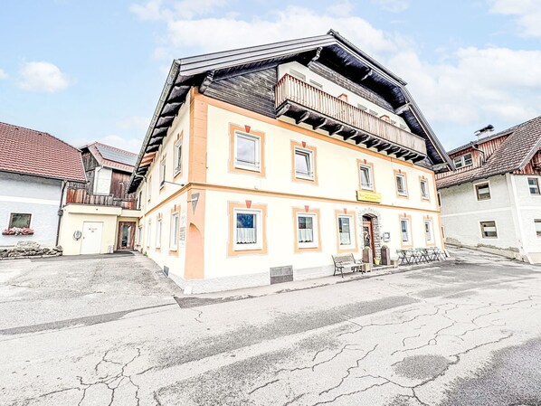 A multi-story building with a traditional architectural style, featuring a balcony on the upper floor.