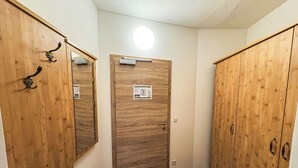 A hallway with wooden wardrobes and a door with a sign.