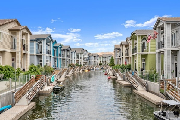 A canal lined with multi-story buildings, each with balconies and a waterway in the middle.