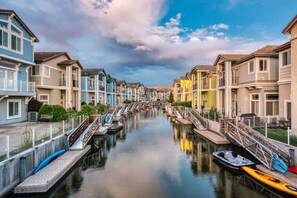 A canal lined with multi-story buildings, a calm waterway, and boats docked along the canal. - Waterfront Oasis w/ Kayaks, Fire Pit & Game Room (Sparks)