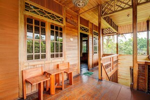 Eine Holzhütte mit Veranda, mehreren Fenstern und einer Treppe zu einer oberen Ebene.