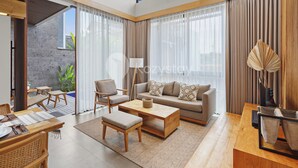 A modern living room with a sofa, chairs, a coffee table, and a dining area with a table and chairs.