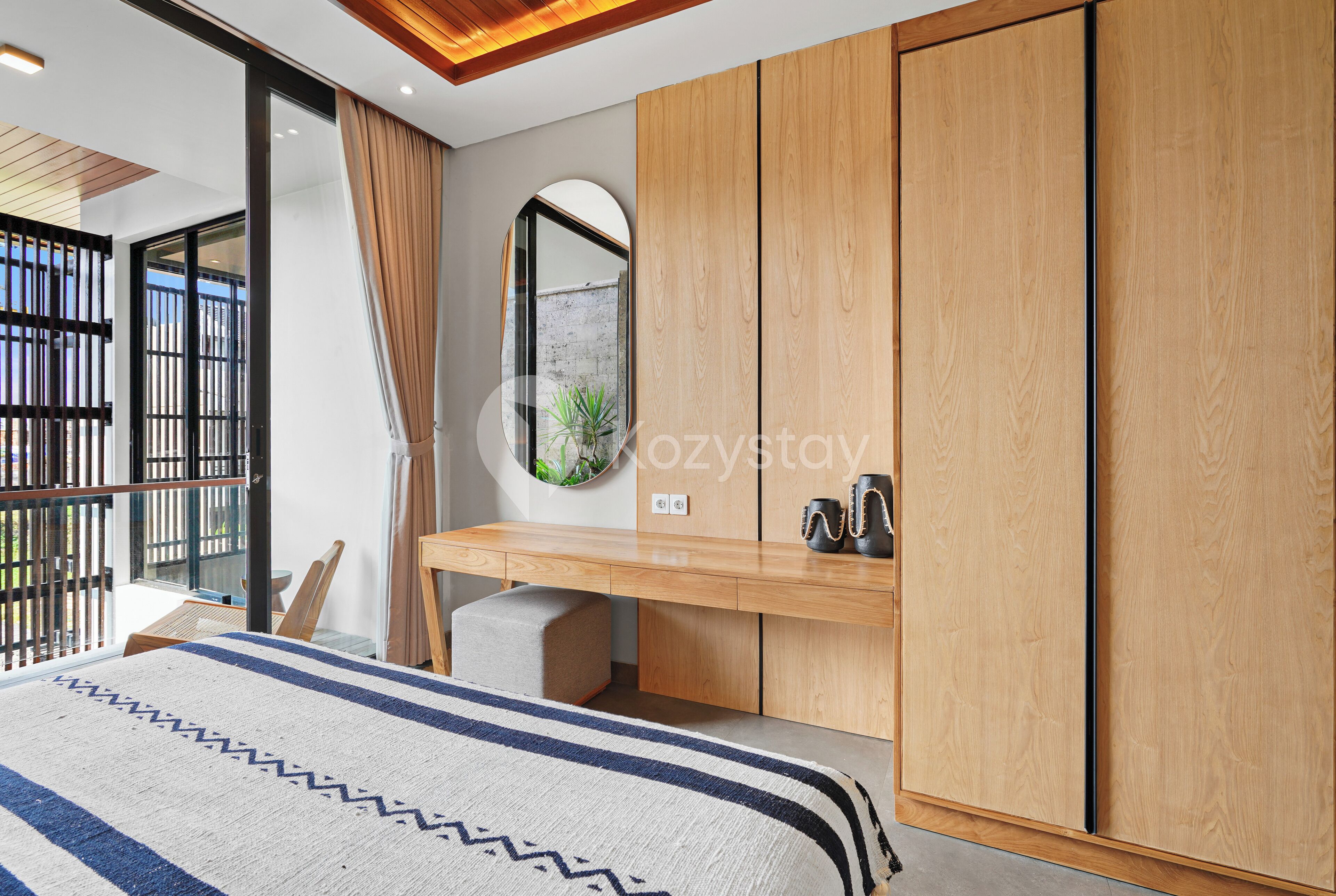 Un dormitorio moderno con una cama grande, un armario de madera y un escritorio con espejo.