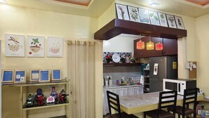 A compact kitchen with a dining area, featuring a marble floor, a small refrigerator, a microwave, and a sink. - Cozy House for Rent in Dadiangas, General Santos City (General Santos)