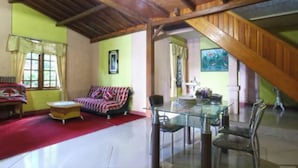 A spacious living area with a high ceiling, a glass dining table, and a red carpet. - Belvilla Bogor near Citra Alam Riverside formerly Jatimas Hijau (Cisarua)