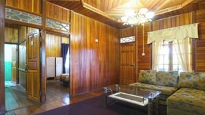 A wooden interior with a sofa, a coffee table, and a chandelier. - Belvilla Bogor near Citra Alam Riverside formerly Jatimas Hijau (Cisarua)
