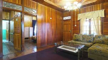 Un interior de madera con un sofá, una mesa de centro y una araña.