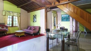 A spacious living area with a high ceiling, a glass dining table, and a red carpet. - Belvilla Bogor near Citra Alam Riverside formerly Jatimas Hijau (Cisarua)