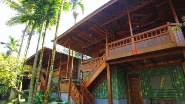 A wooden building with multiple balconies and a staircase. - Belvilla Bogor near Citra Alam Riverside formerly Jatimas Hijau (Cisarua)