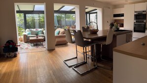 Una cocina moderna con comedor, ventanas amplias y vista al patio trasero.